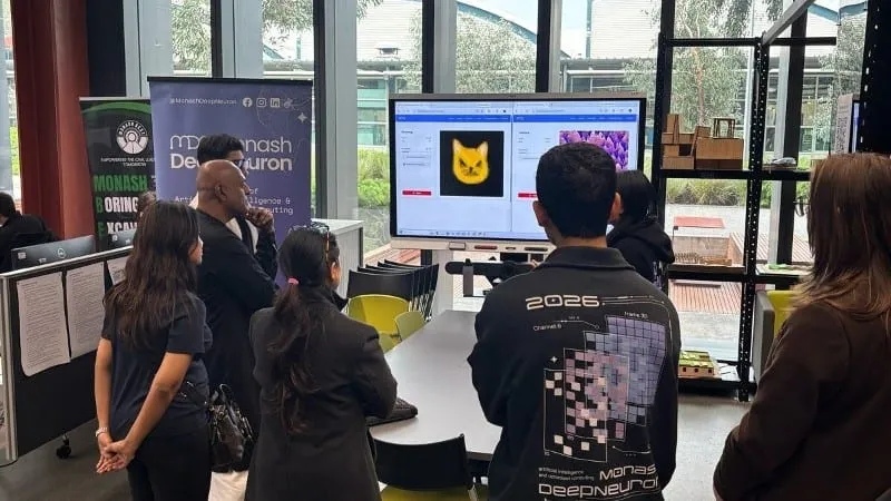 Visitors at a Monash DeepNeuron showcase booth watching an Omni AR demo.